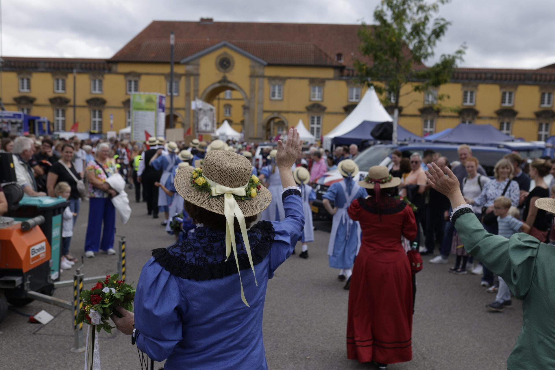 _CW_8696 CW_8696.jpg: Menschen in Trachten und Hüten winken auf einer Veranstaltung. Landeshauptstadt Flair.