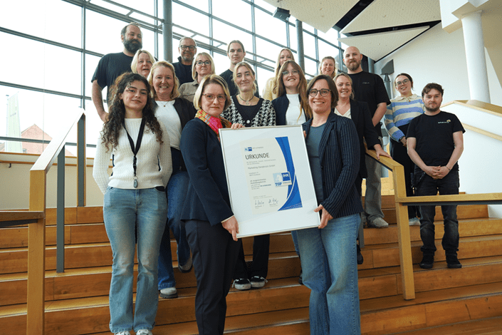 IHK-Top-Ausbildungsbetrieb Marketing Osnabrück: Team mit Urkunde, Auszeichnung für Top Ausbildung.
