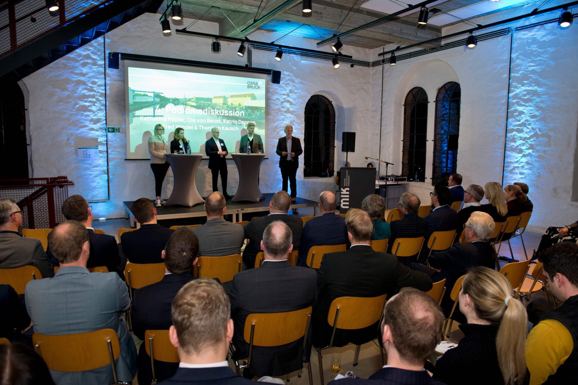 Zukunftsforum in der Osnabrück Arena: Podium mit Diskussionsteilnehmern vor Publikum. Premiere für Impulse am Standort.