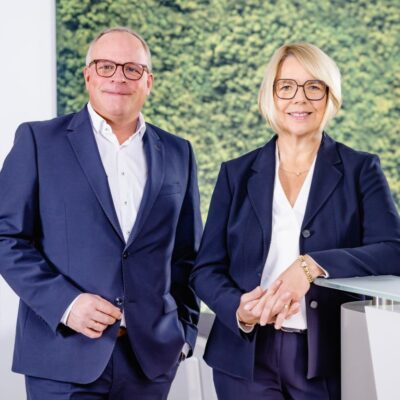 Quadrat-Heiko Engelhard Beate Jakobs: Porträt von Heiko Engelhard und Beate Jakobs, beide im Business-Look mit Anzug und Brille.